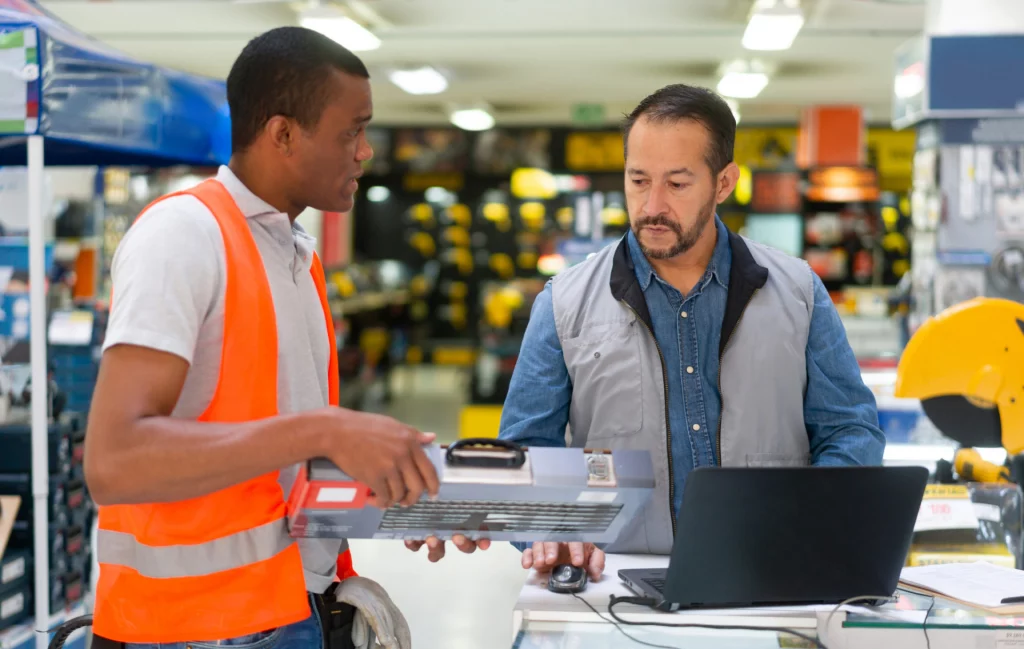 Salesman helping a customer buying a toolbox at a hardware store - small business concepts