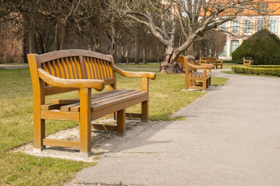 Un banc en bois vide se trouve près d’un sentier.