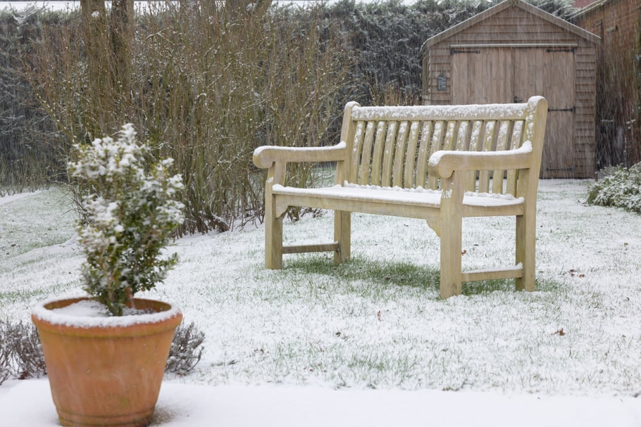 Un banc en teck couvert de neige.