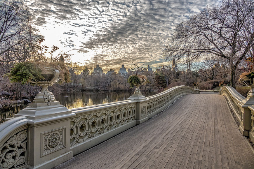 Un pont gris en fonte avec des fleurs et autres décorations, à Central Park