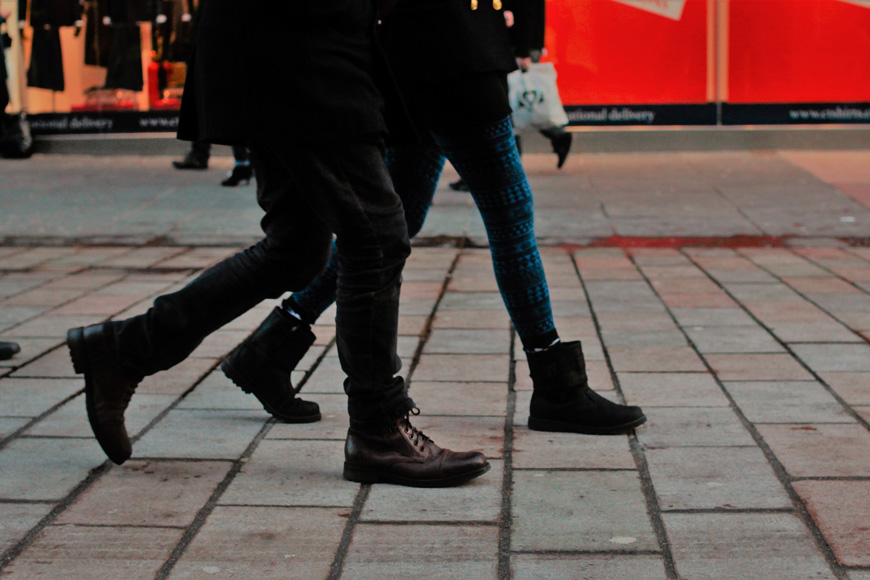 Two people walk on a city street