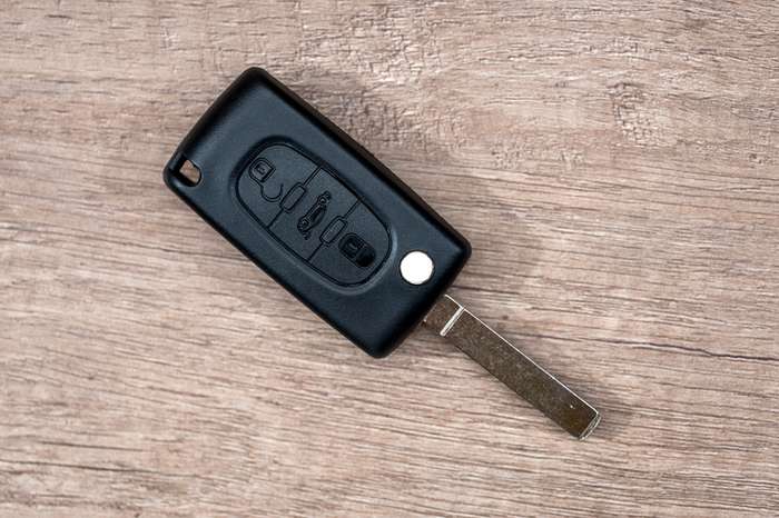 Black car key on wooden desk