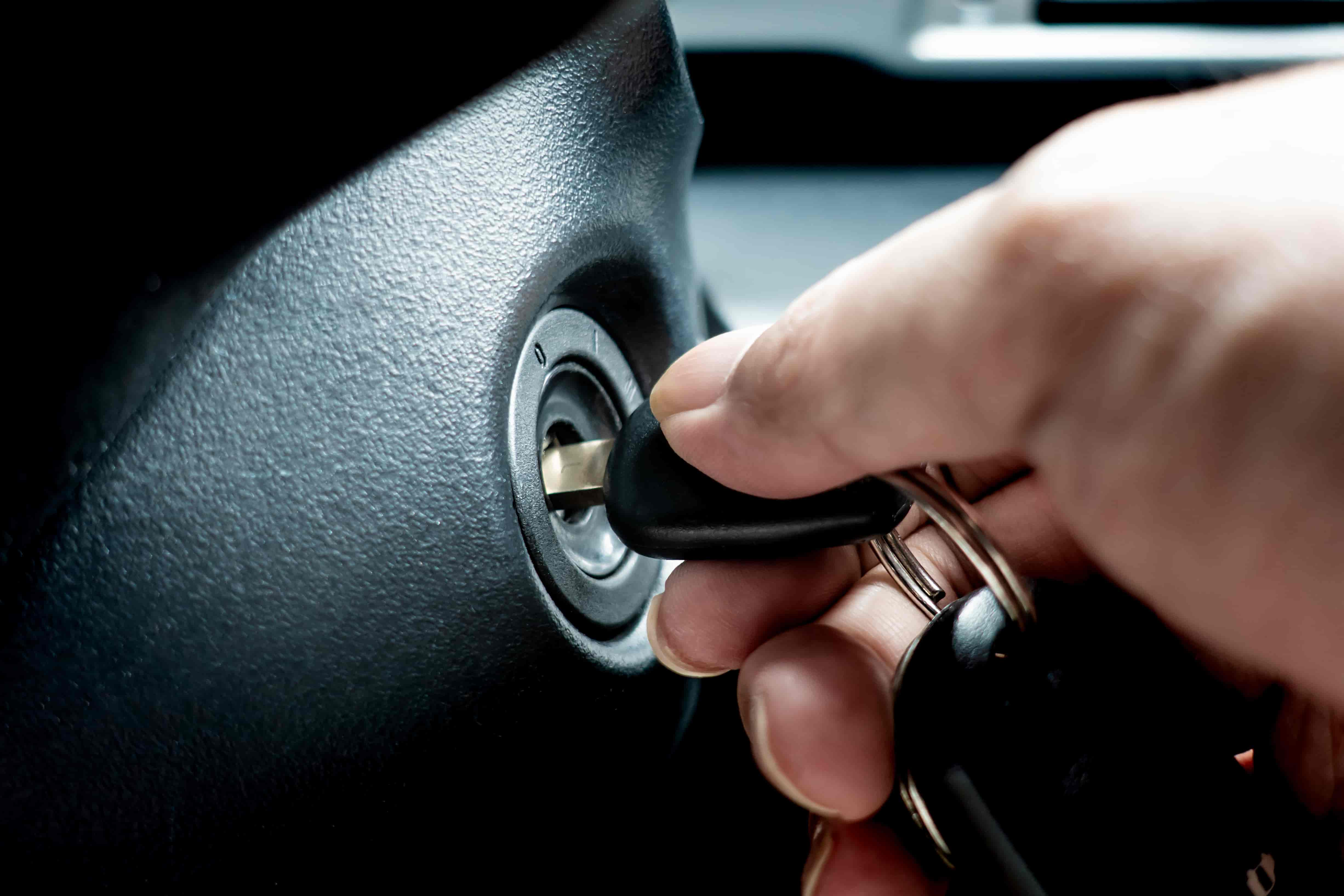 hand turning car key in keyhole to start engine