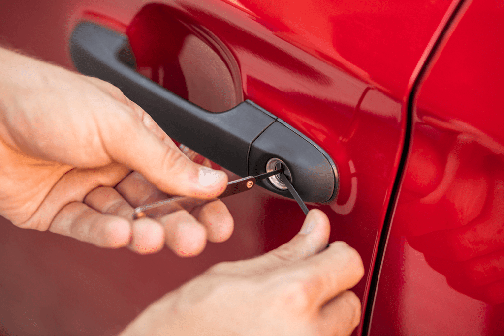 locksmith using lock picks to open car door